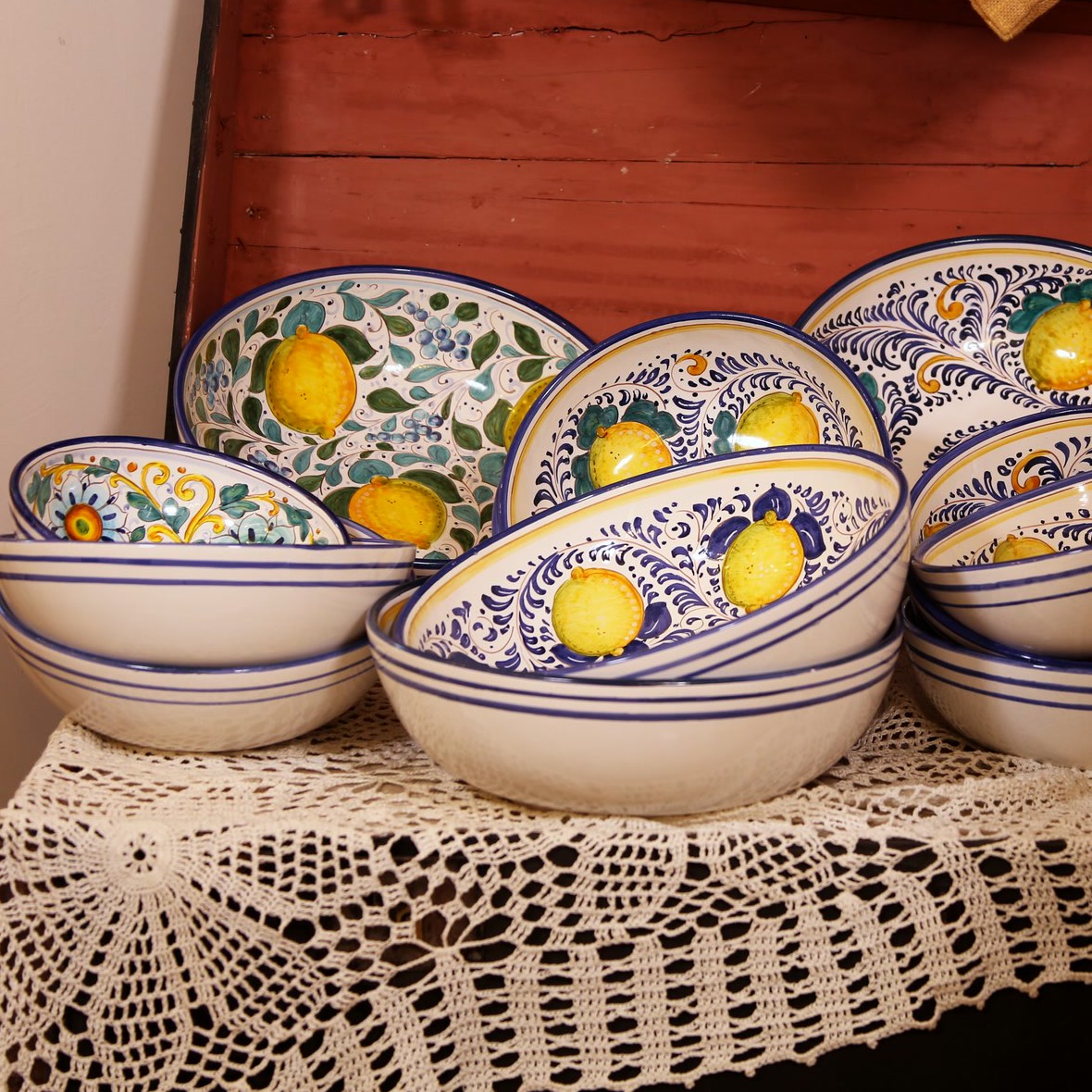 Ciotole in ceramica con limoni dipinti a mano impilate su una tovaglia a uncinetto