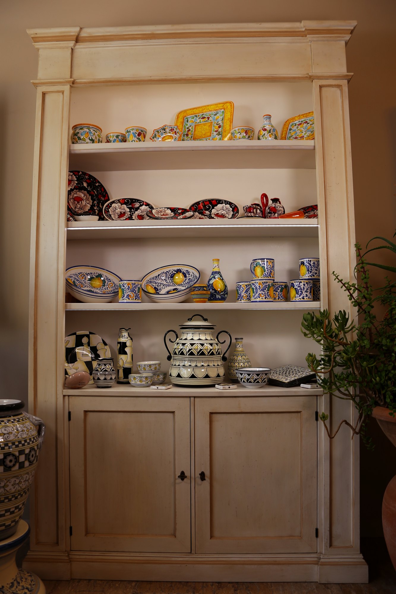 Credenza con piatti neri e rossi e vassoio giallo