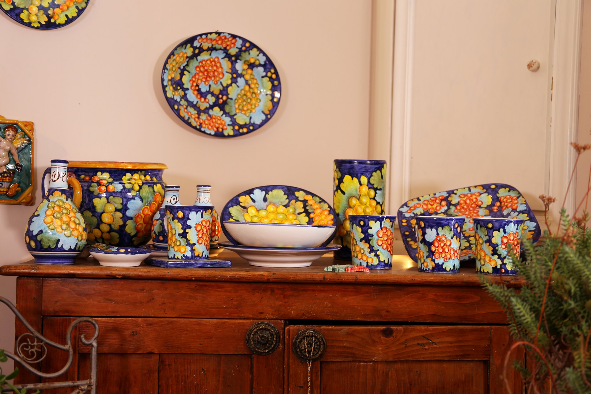 Servizio con decoro a grappoli su fondo blu su credenza in noce