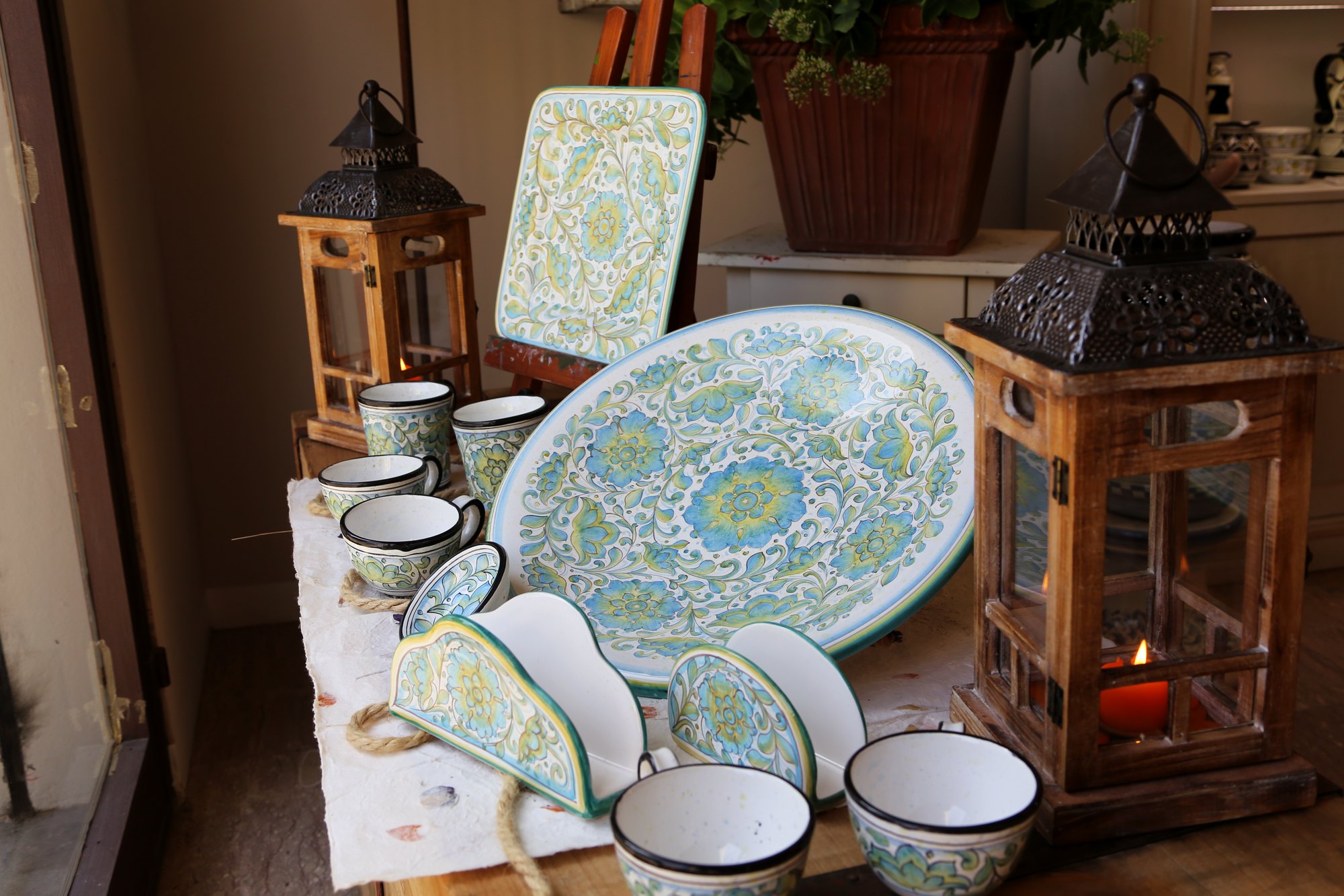 Dinner set with flowers on a pale blue ground laid out in the workshop